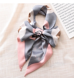 Detail of elegant geometric ribbon scarf with heart print tied in a bow on linen