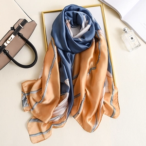 Elegant floral silk scarf in navy blue and amber gold finish for a luxury spring look