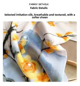 Detail of silk-like scarf fabric showing yellow floral patterns and smooth texture