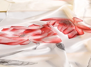 Detailed macro view showing the glossy silk texture and red lotus pattern on the white scarf