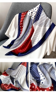 Détail d'un foulard en soie à pois rouges et bleus montrant la texture satinée et motifs