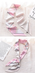Close-up of pink and grey silk scarf with elegant chain patterns and geometric logos
