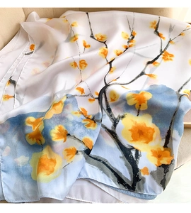 Detail of silk-feel scarf featuring artistic plum blossom print and elegant drapery texture