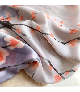 Macro shot of silk-like scarf featuring elegant floral patterns and smooth texture