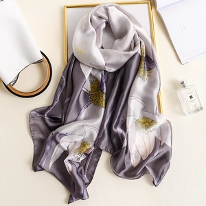Elegant silk scarf with lotus pattern displayed with stylish accessories in soft light