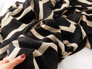 Close-up of geometric striped scarf showing premium woven texture and matte finish