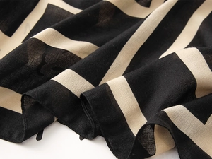 Close-up of lightweight linen texture fabric with abstract geometric black and beige patterns