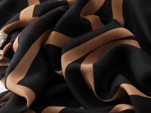 Detail of soft cotton-linen feel shawl featuring classic black and tan diagonal stripes