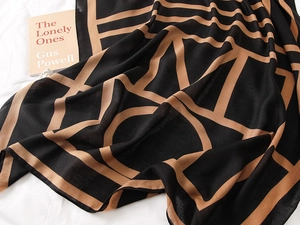 Close-up of lightweight cotton scarf with modern geometric lines and neutral tones