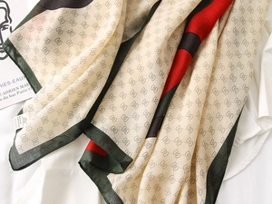 Detail of soft cotton linen scarf featuring classic red green stripes and geometric patterns