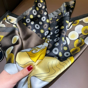 Close-up of printed silk square scarf with geometric and floral patterns in retro style