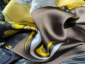 Macro view of luxurious silk scarf fabric with multi-color floral and geometric patterns