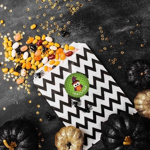 Detail of owl sticker on candy bag with Trick-Or-Treat text and Halloween decorations