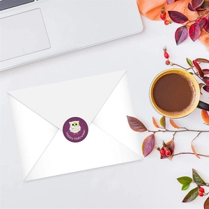 Happy Halloween owl sticker sealing a white envelope in a cozy autumn desk setting