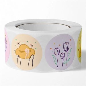 Close-up of cute cartoon stickers on a roll with hand-drawn floral and sun patterns