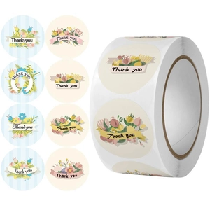 Macro detail of round floral Thank You labels showing diverse watercolor patterns on rolls