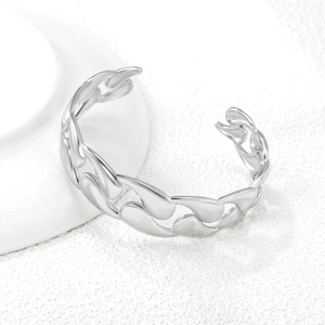 Macro detail of a high-polished silver chain cuff bracelet with a glossy mirror finish