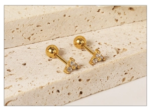 Detailed view of gold triangular stud earrings with zircon stones and screw-back ball closure