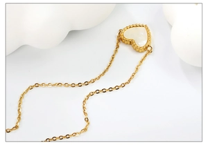 Détail du pendentif cœur doré avec nacre blanche et bordure perle sur chaîne fine