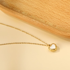 Lava heart necklace in 18k gold stainless steel with white shell inlay on yellow background