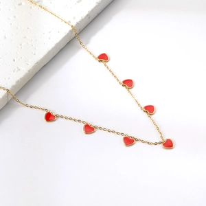 Detailed close-up of 18K gold heart charms on a dainty stainless steel necklace chain