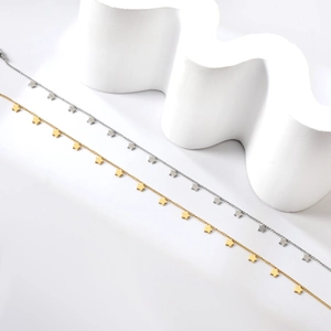 Minimalistische Fußkettchen aus Edelstahl mit Sternen in Gold und Silber auf weißem Dekor