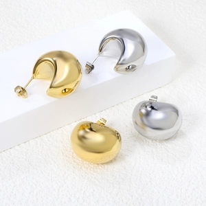 Polished thick C-shaped hoop earrings in gold and silver finish on display
