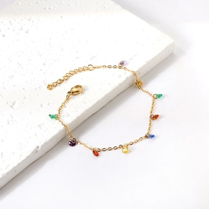 Bracelet chaîne en or avec pierres colorées et fermoir réglable sur pierre blanche