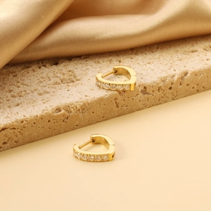 Detailed view of gold heart earrings with sparkling white cubic zirconia pavé setting