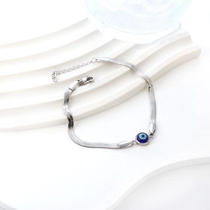 Polished stainless steel snake chain bracelet with blue evil eye bead on white stand