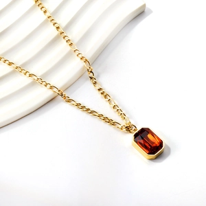 Detail of a vintage gold-plated necklace with a rectangular orange amber stone pendant