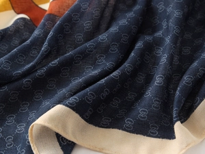 Detail of soft navy cotton scarf showing fine knit texture and classic pattern design