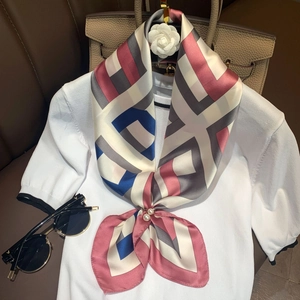 Detail of silk scarf with geometric patterns and elegant double pearl scarf buckle clip