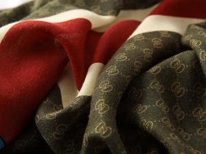 Macro detail of the elegant green and red fabric with luxurious gold pattern textures