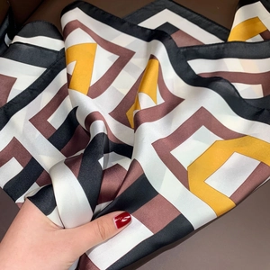 Detailed view of geometric pattern silk scarf with black white and brown colors