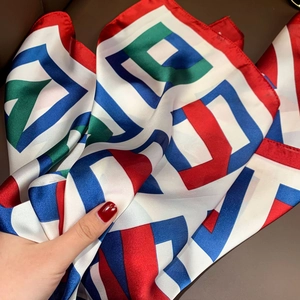 Detailed view of the smooth texture and rolled edges of a colorful geometric silk scarf