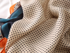 Close-up of lightweight polka dot scarf with vibrant blue and orange color blocking