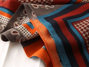 Detailed close-up of paisley and geometric printed scarf with premium stitched edges