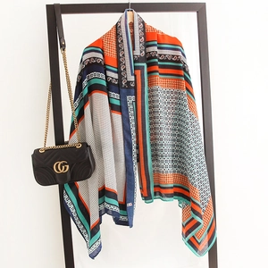 Detail of multi-patterned shawl featuring colorful paisley, dots, and stripes motifs