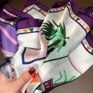 Detail of silk-like scarf with tropical palm leaves print and purple border design