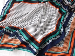 Detail of vibrant paisley and polka dot printed scarf with soft linen-feel texture