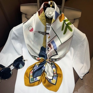 Artistic printed silk scarf on knit top with a gold ring clasp and leather bag