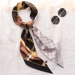 Long silk-like scarf with gold chain and monogram pattern on beige background