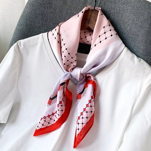 Écharpe satinée rose et rouge avec motifs géométriques et grille sur t-shirt blanc