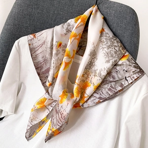 Élégante écharpe en soie avec motifs de feuilles de ginkgo jaunes sur t-shirt blanc