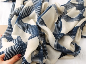 Close-up of lightweight cotton linen scarf with navy blue plaid patterns and soft texture