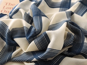 Close-up of blue and white plaid scarf with fine stripes and soft linen texture