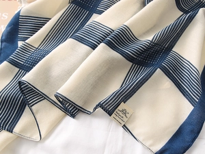 Close-up of blue and white checkered cotton linen scarf with fine hem and brand tag