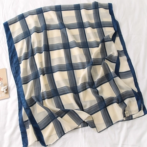 Detailed close-up of navy and cream plaid scarf with soft cotton-linen texture