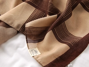 Close-up of cotton-linen feel scarf showing textured brown and beige plaid weaving details